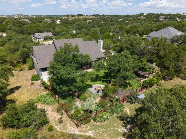 Aerial view of a Hill Country home on a wooded acreage lot in Dripping Springs, Texas